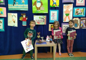 Dzieci z grupy Żuczków pozują z nagrodami za udział w konkursie Łódź Bajkowa na tle prac konkursowych